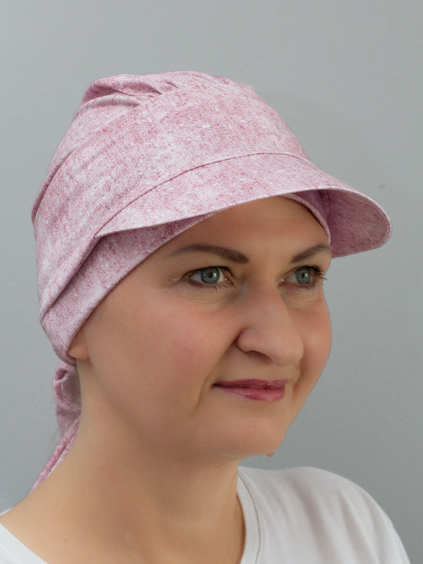 Lightweight bamboo hat with a band, cap peak for sun protection, and gentle melange tones, ideal for alopecia and sensitive scalps